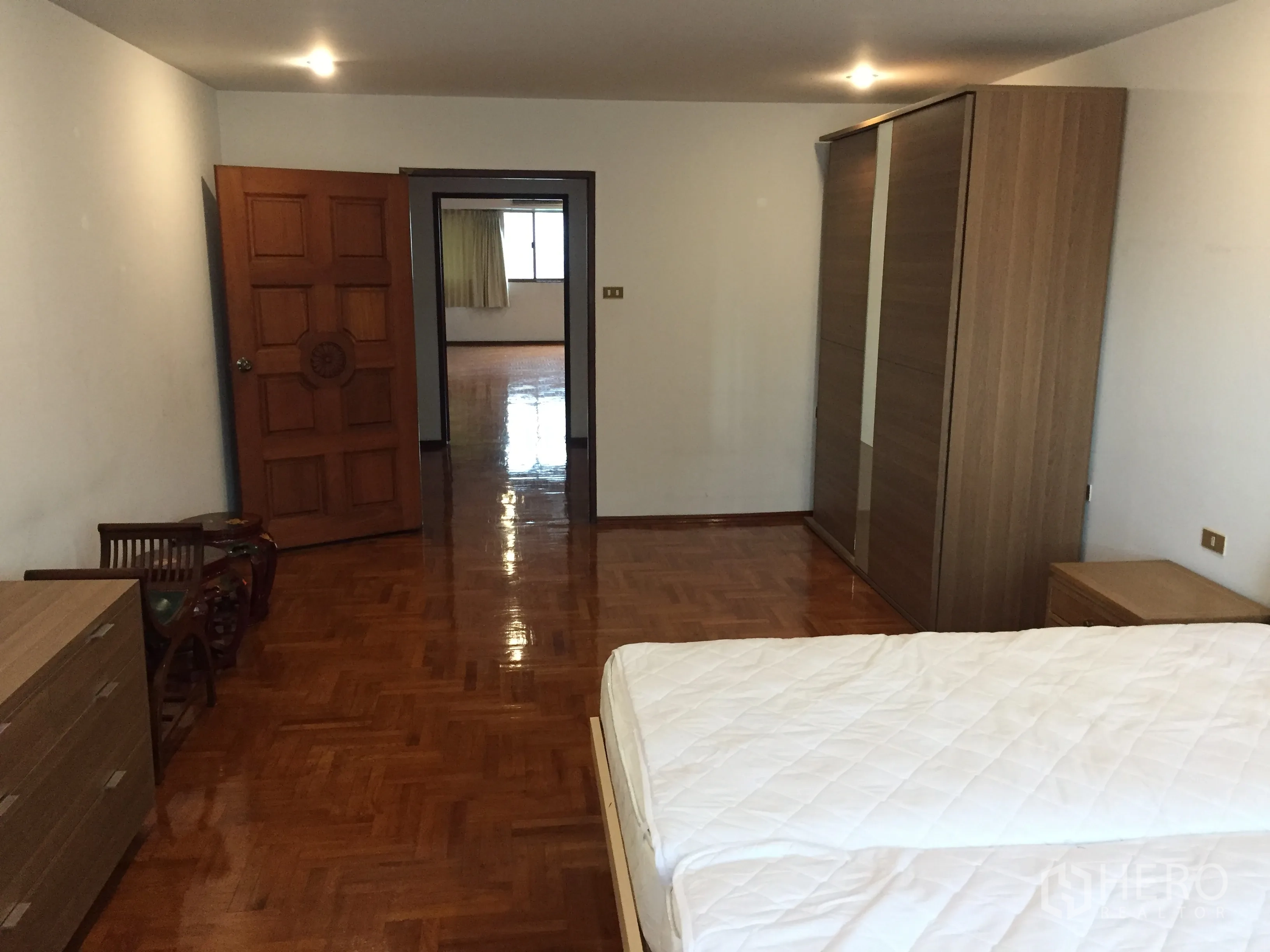 公寓 出租在Watthana, Bangkok - 从卧室望向客厅的角度，推拉衣柜与木地板