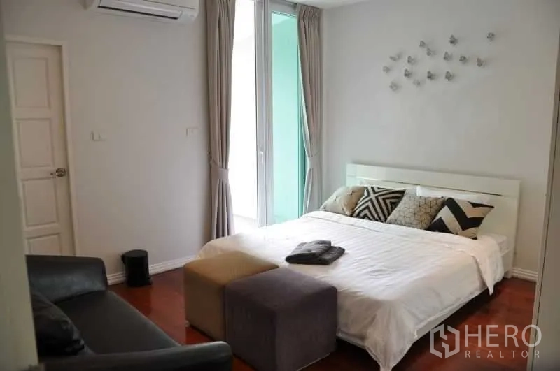 联排别墅 出租或出售在Watthana, Bangkok - 温馨卧室，设床与脚凳及沙发，配色素雅，自然采光好。