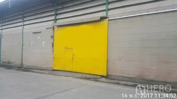 工厂 出租在Bang Phli, Samut Prakan - 工厂外立面，明黄色大滑门，临混凝土车道，便于货车进出。