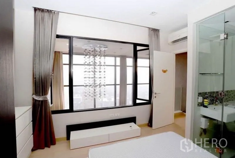 公寓 出租在Khlong San, Bangkok - 卧室设内窗与客厅相连，通往套内卫生间