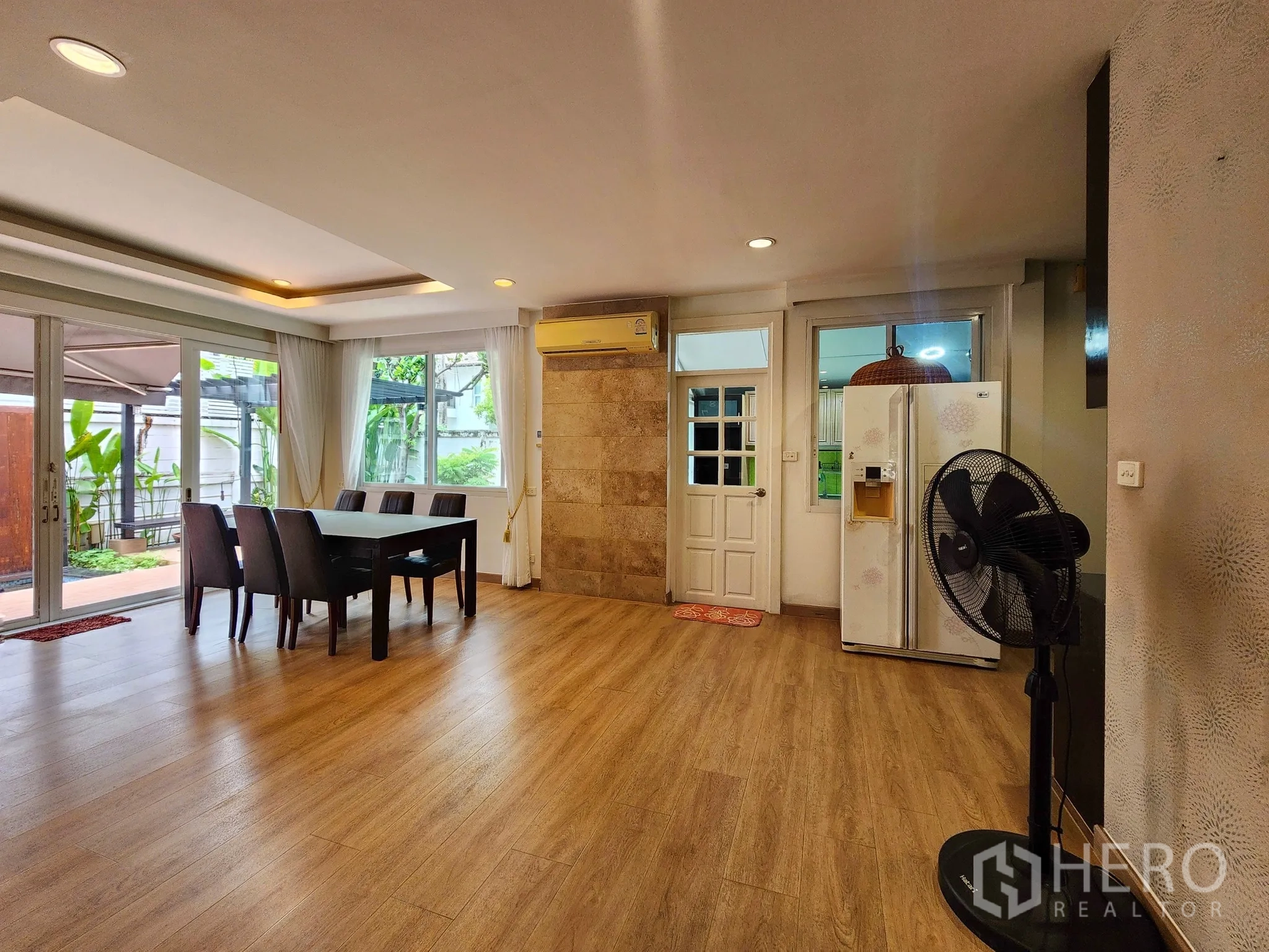 Detached House for rent in Bang Kapi, Bangkok - Dining room with sliding glass doors opening to a terrace and garden.