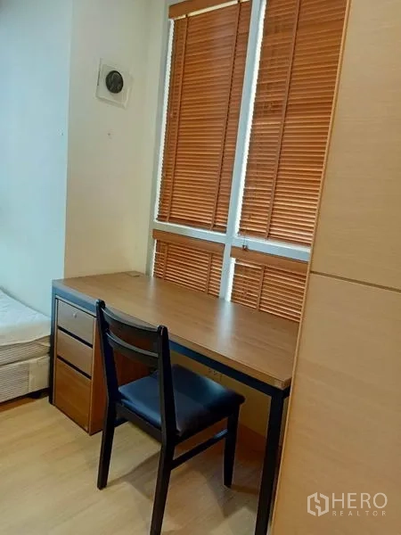 公寓 出租在Bang Rak, Bangkok - 紧凑书写角，书桌椅靠窗，配木质百叶。