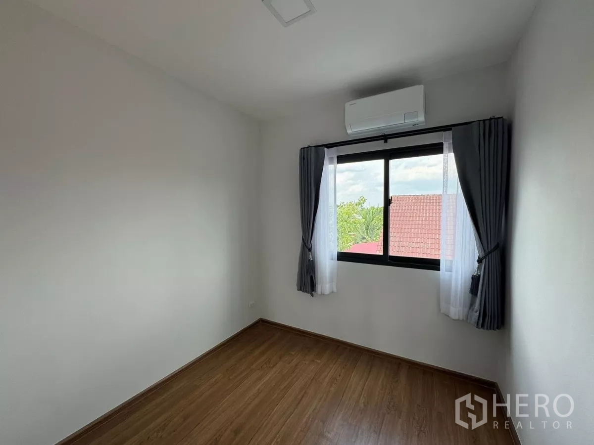 Townhouse for rent in Bang Phli, Samut Prakan - Empty bedroom with wood-look flooring, large window, and AC
