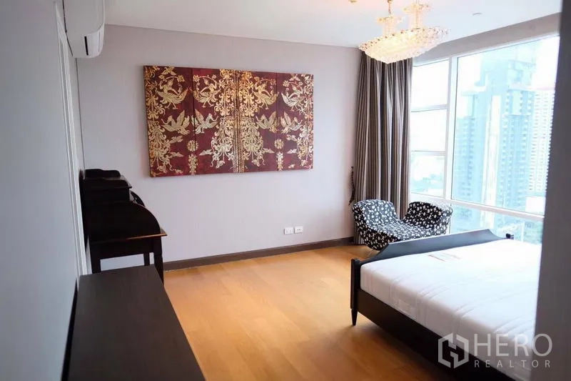 公寓 出租在Watthana, Bangkok - 宽敞主卧，水晶吊灯、落地窗与休闲椅