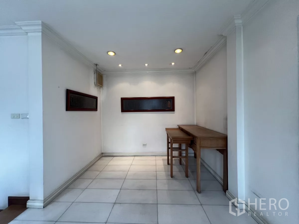 Townhouse for sale in Watthana, Bangkok - Utility or multipurpose room with tiled floor and small wooden tables.