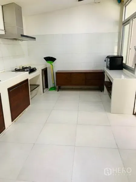 Townhouse for rent or sale in Huai Khwang, Bangkok - Simple kitchen with gas hob, range hood, white countertops and large windows