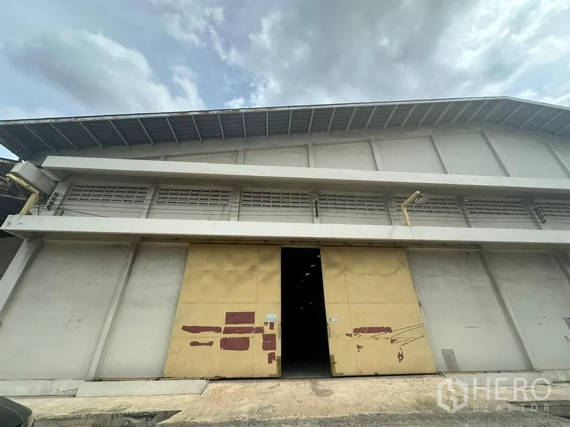Warehouse for rent in Yan Nawa, Bangkok - Front facade of the warehouse showing a tall sliding door and loading ramp access.