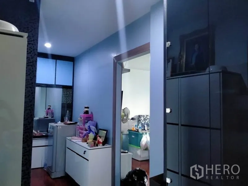独立式住宅 出售在Thawi Watthana, Bangkok - 走廊蓝色墙面与柜体，嵌入式照明，通往相邻房间。