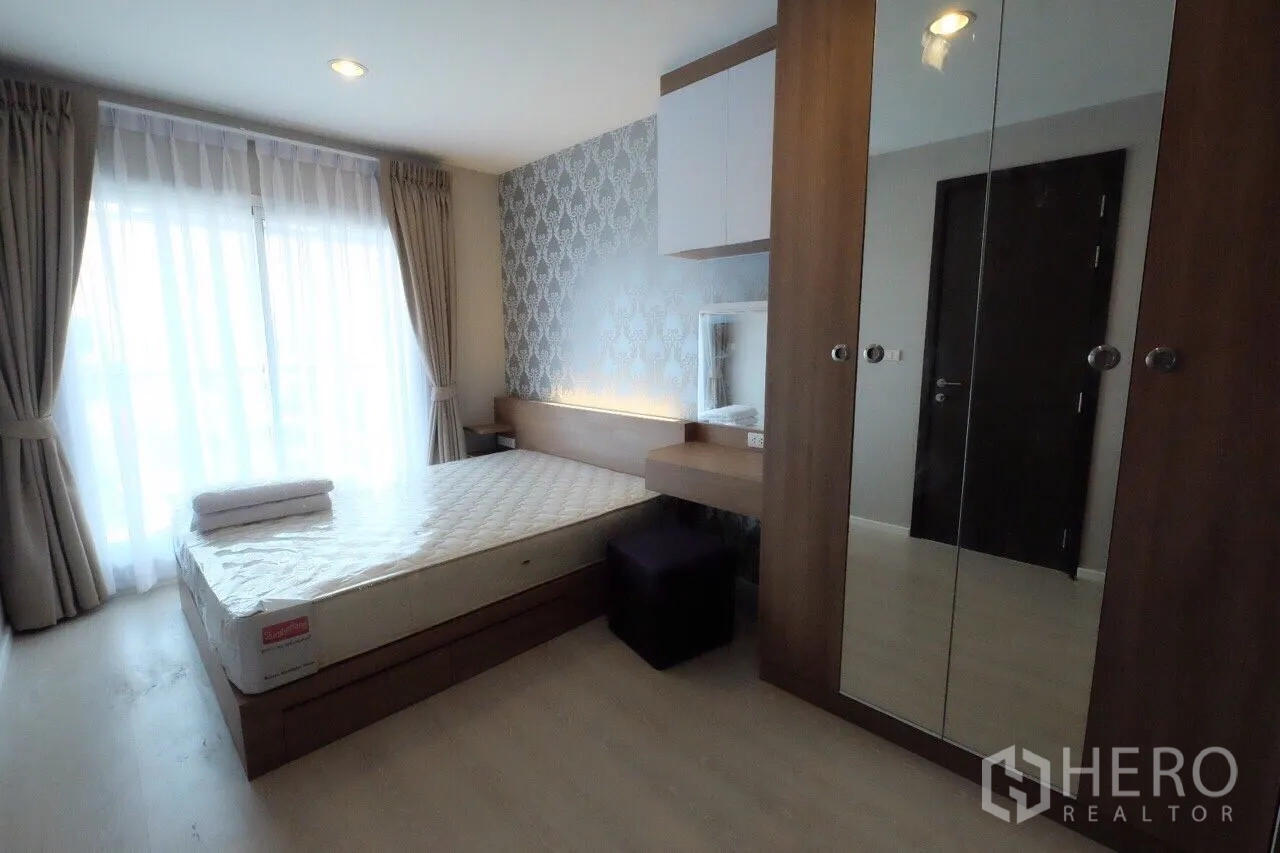 Condominium for rent in Sathon, Bangkok - Bedroom with floor-to-ceiling curtains, built-in headboard with soft lighting, mirrored wardrobe and queen bed.