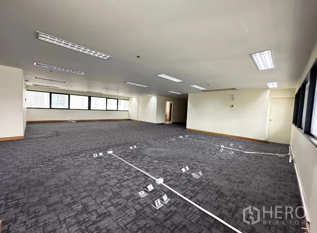 Office Space for rent in Bang Rak, Bangkok - Open workspace with floor cable trunking and a row of black-framed windows.
