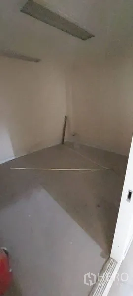 零售空间 出租 - 小型昏暗储物间，墙面简洁并有顶灯。