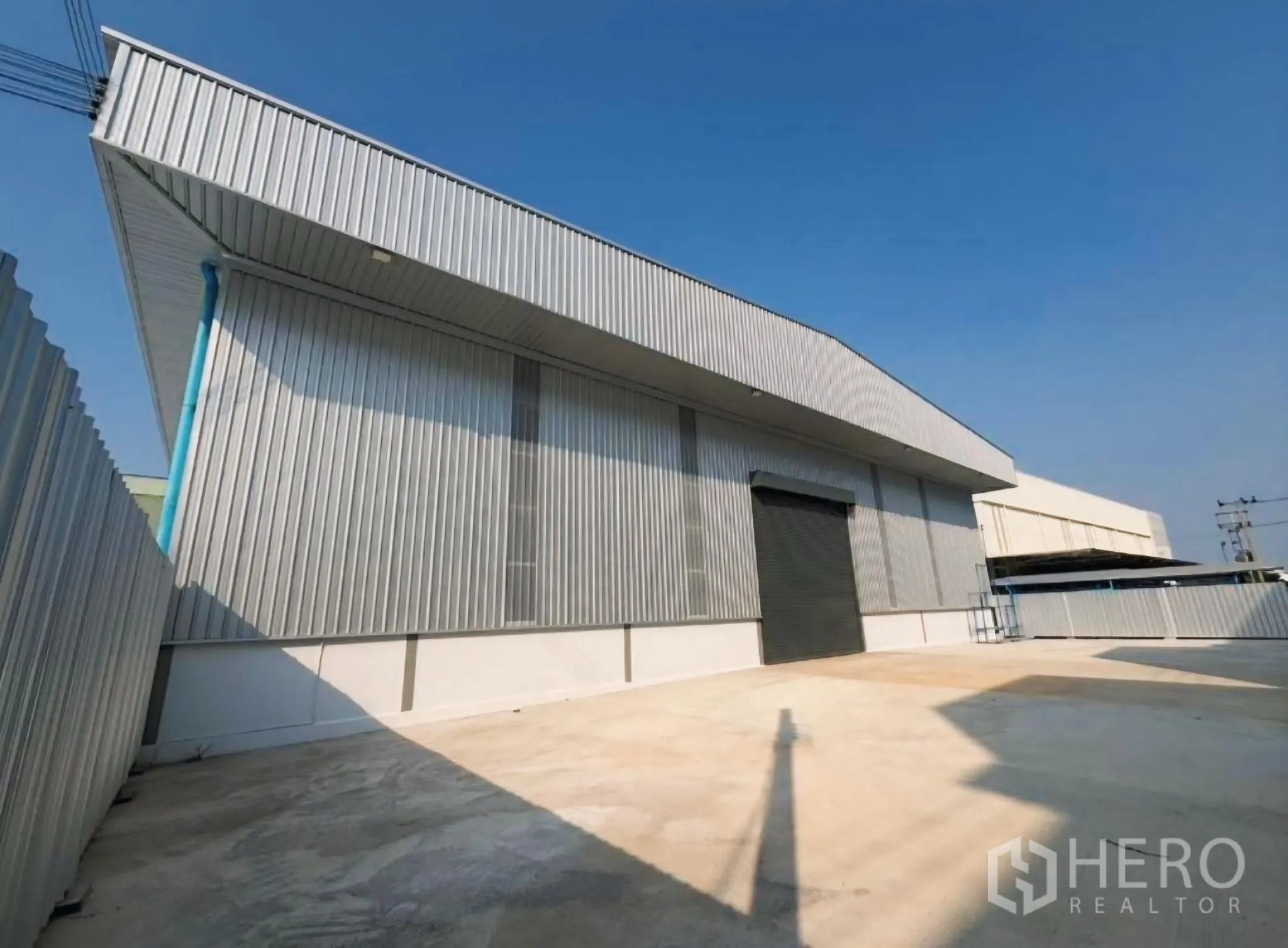 โกดัง for rent in Bang Khun Thian, Bangkok - ด้านหน้าโกดังพร้อมประตูม้วนและลานโหลดสินค้าคอนกรีตกว้าง