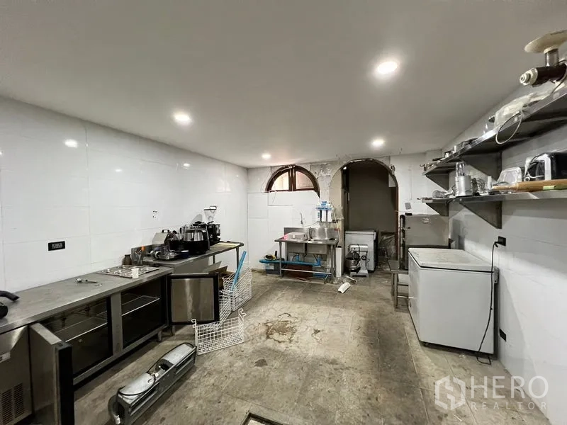 Shophouse for rent in Watthana, Bangkok - White-tiled utility room with shelves, refrigerator, and sink.