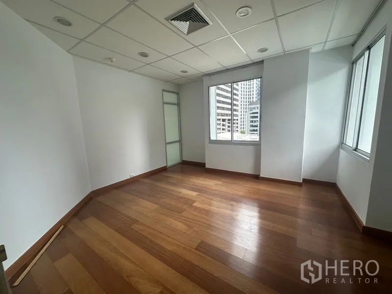 Office Space for rent in Bang Rak, Bangkok - Private corner office with wood flooring and city-view windows.