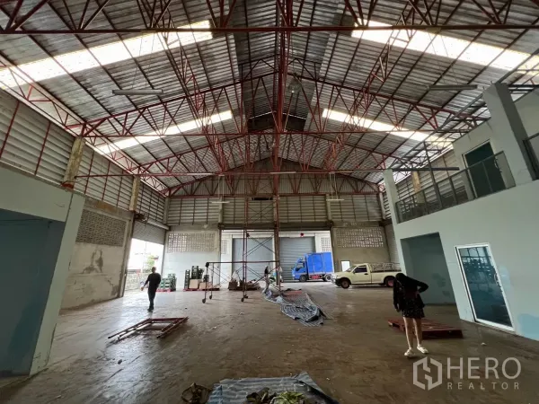 Warehouse for rent in Khlong Sam Wa, Bangkok - High-ceiling warehouse interior with red steel trusses, mezzanine offices and multiple roller shutters in Khlong Sam Wa.