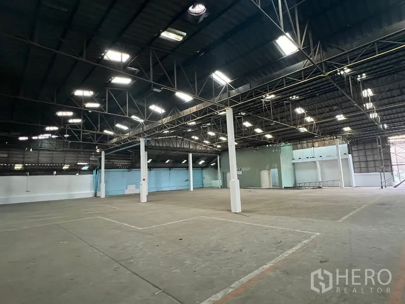 Warehouse for rent in Samut Prakan - Open warehouse bay with marked loading zones and bright skylights.