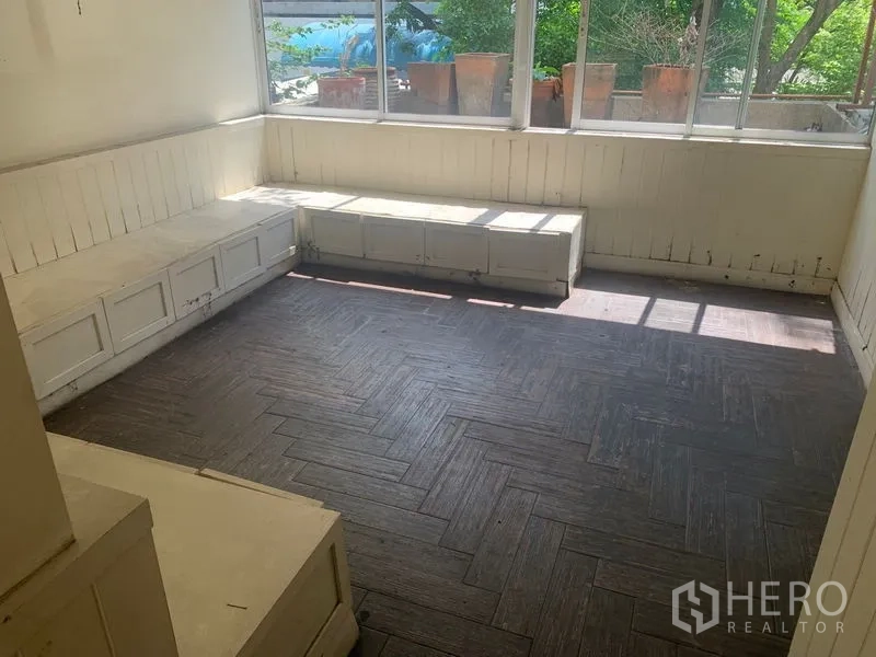 Shophouse for rent in Watthana, Bangkok - Bright corner room with built-in bench seating and full-height windows.