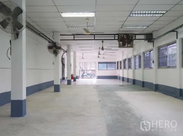 货栈 出租在Bang Kapi, Bangkok - 宽敞大厅，混凝土地面，壁挂风扇与带护栏的窗户，通风良好。