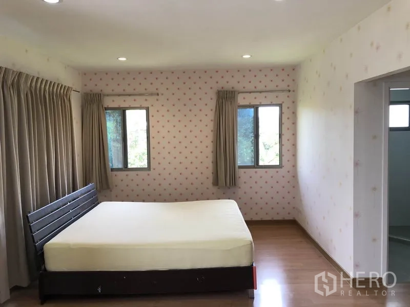 独立式住宅 出租在Suan Luang, Bangkok - 主卧室，双向窗户、窗帘与木地板