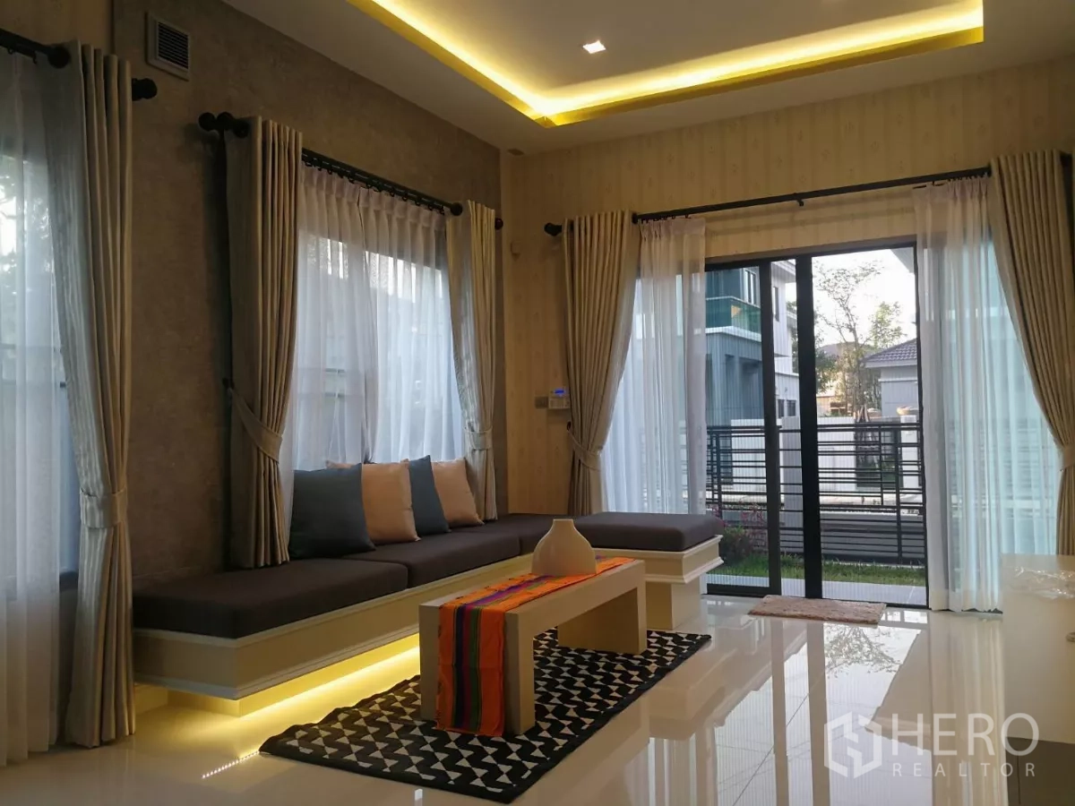 独立式住宅 出售在Lat Krabang, Bangkok - 采光充足的客厅，落地窗与推拉门，内置长凳并配有氛围灯。