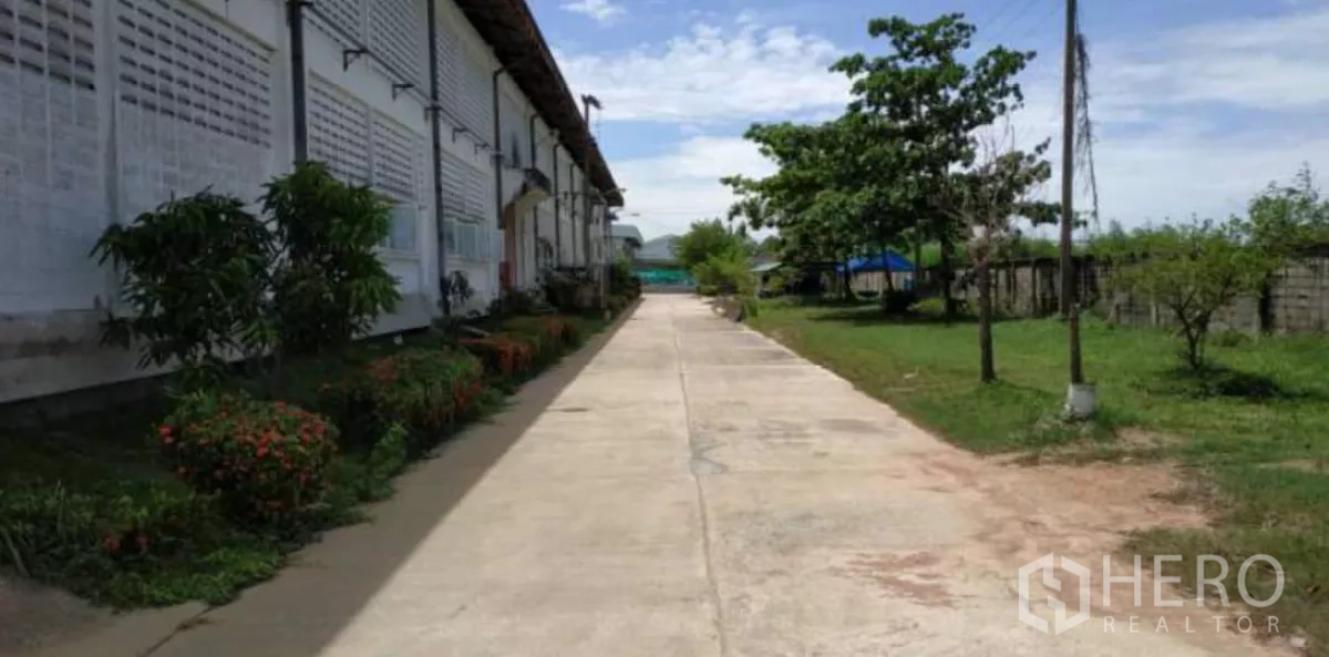 工厂 出租在Bang Pakong, Chachoengsao - 工厂侧边步道与花坛及草地，通行空间适合卡车进出。
