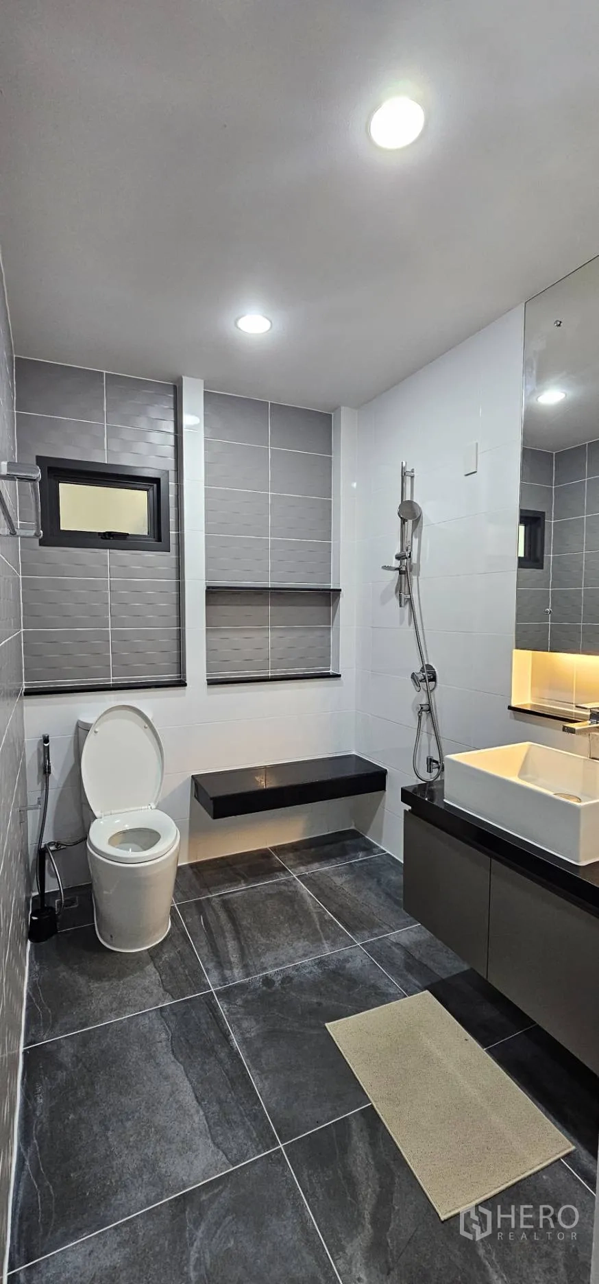 Detached House for rent in Bang Kapi, Bangkok - Second bathroom with grey tiles, walk-in shower and floating vanity.