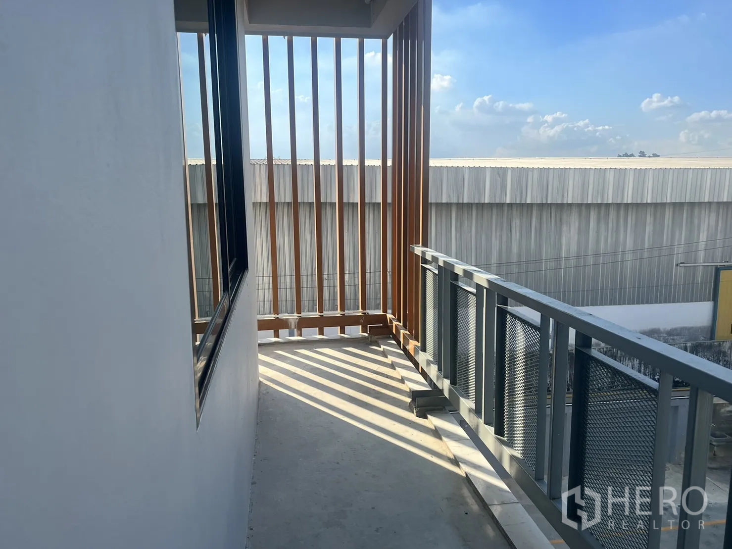 办公空间 出租在Lat Krabang, Bangkok - 狭长阳台通道，金属栏杆与竖向遮阳百叶。