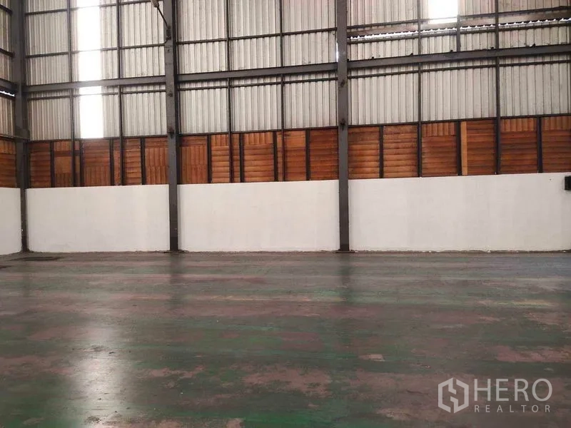 Warehouse for rent in Mueang Samut Sakhon, Samut Sakhon - Side wall with ventilation panels above white lower walls and epoxy-coated floor.