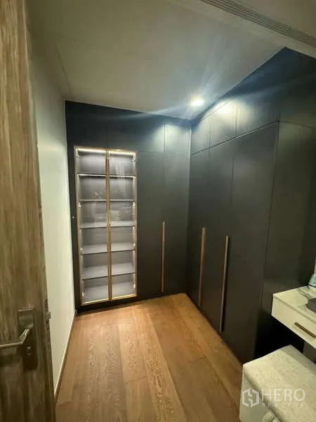 公寓 出租在Khlong Toei, Bangkok - 步入式衣帽间，深色定制衣柜与温暖木地板。