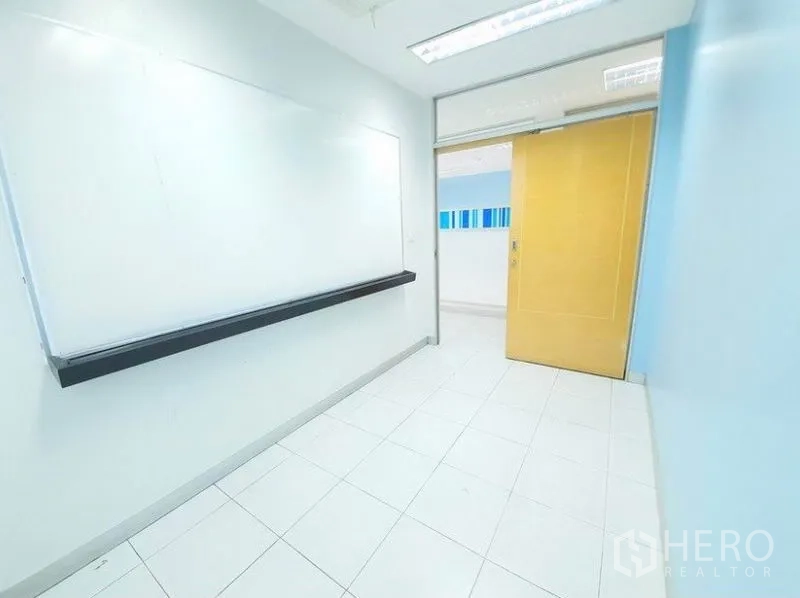 Office Space for rent in Bang Na, Bangkok - Narrow meeting space featuring a wall-mounted whiteboard and sliding wooden door.