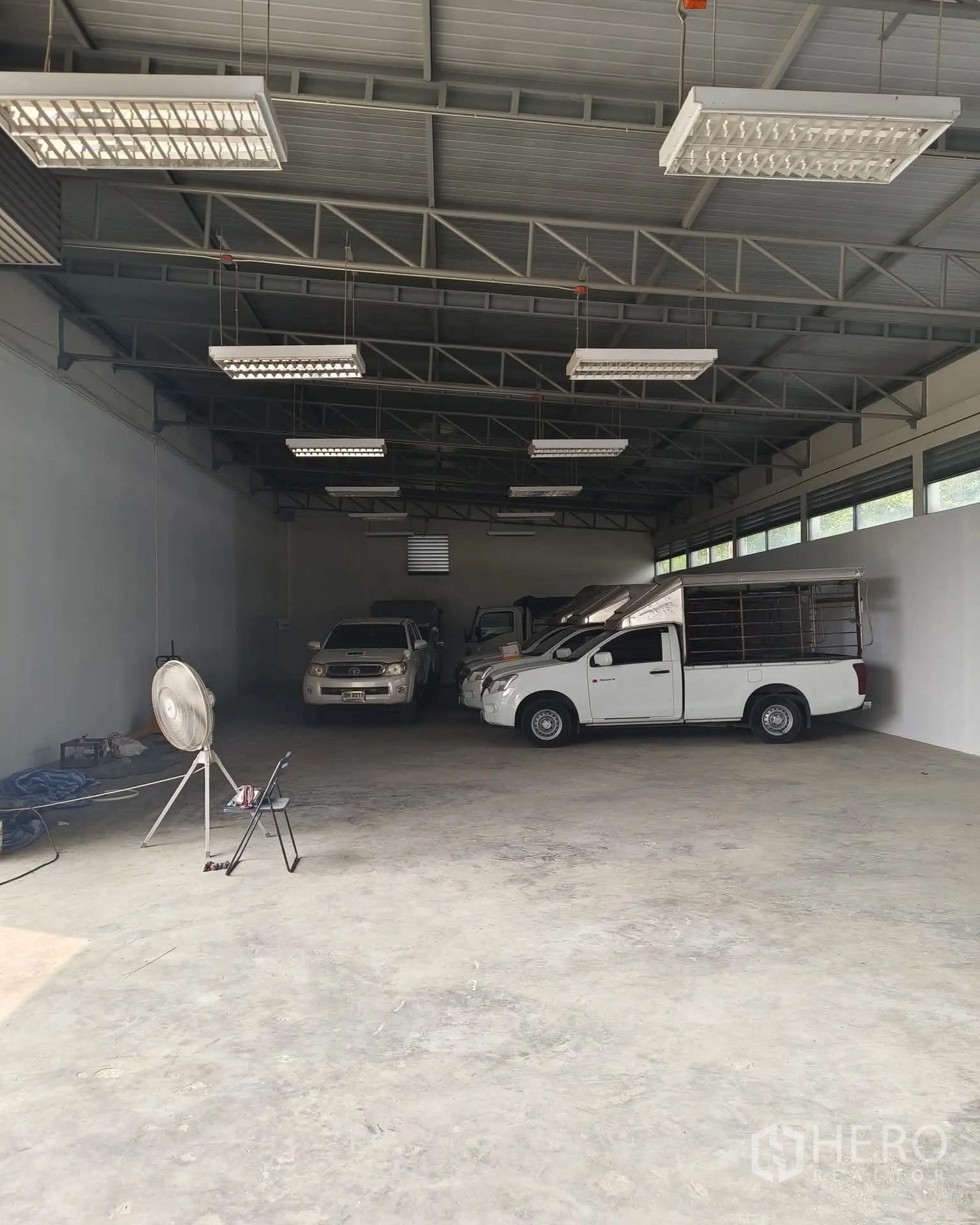 仓库 for rent in Sai Mai, Bangkok - 宽敞仓库内景，高钢结构屋顶、LED照明与平整混凝土地面，可停靠卡车