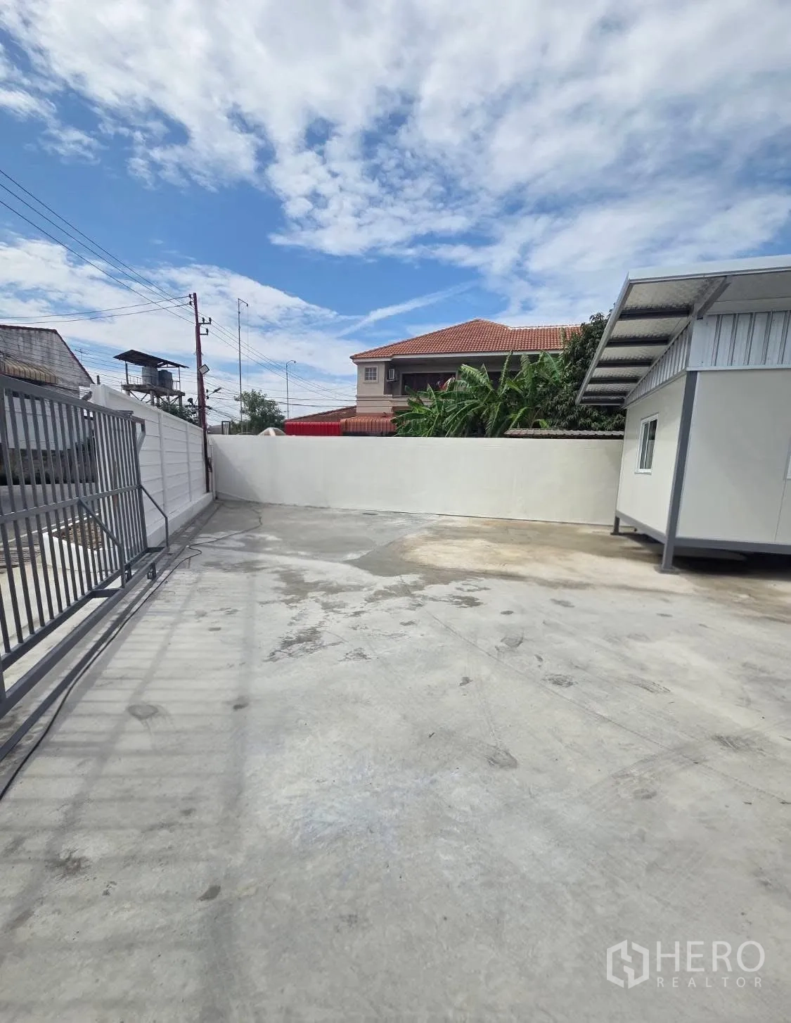 Factory for rent in Mueang Samut Prakan, Samut Prakan - Gated entrance and driveway with high boundary walls and open parking area.