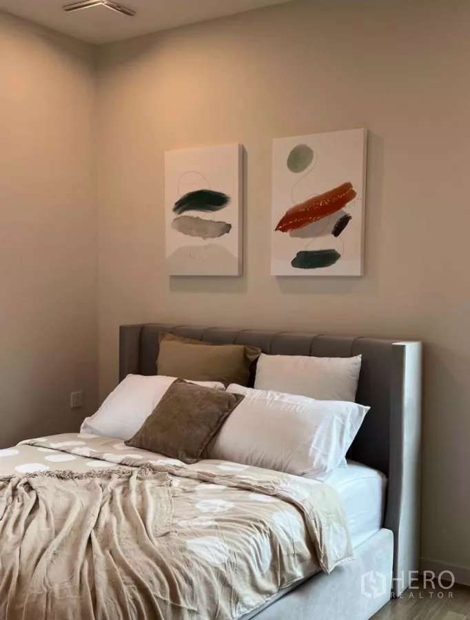 Detached House for rent in Samut Prakan - Guest bedroom with neutral bedding and two abstract artworks above the bed.