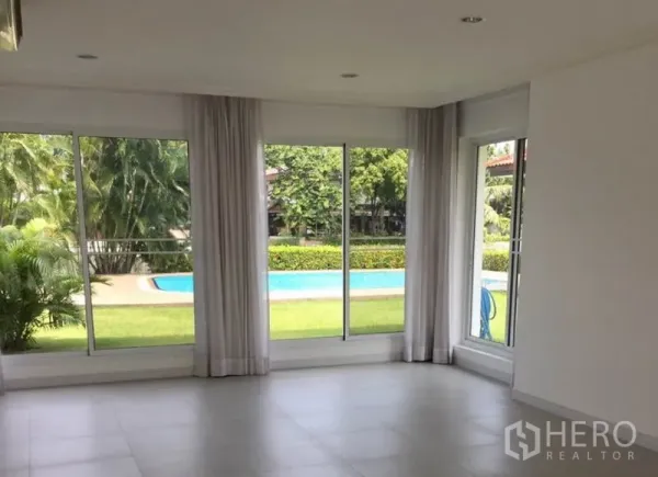 Detached House for rent in Bang Phli, Samut Prakan - Light-filled family room with floor-to-ceiling windows overlooking the garden and swimming pool.