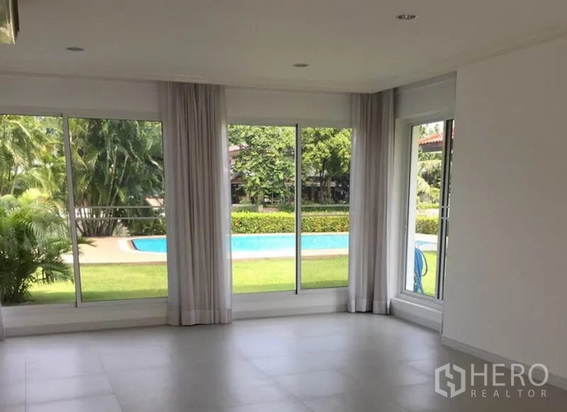 Detached House for rent in Bang Phli, Samut Prakan - Light-filled family room with floor-to-ceiling windows overlooking the garden and swimming pool.