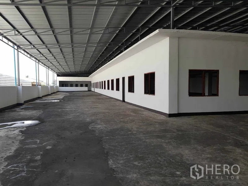 Warehouse for rent in Nong Khaem, Bangkok - Covered open-air corridor beside office rooms under a metal canopy.