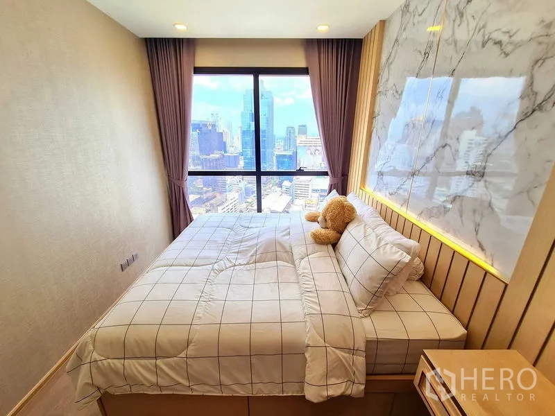 Condominium for rent in Bang Rak, Bangkok - Open-plan living room wrapped in glass with skyline views of central Bangkok.