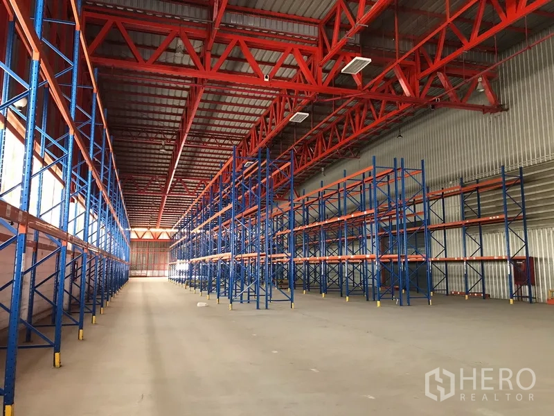 Warehouse for rent in Bang Na, Bangkok - Aisle between pallet racks showing clear‑span space and tall ceiling.