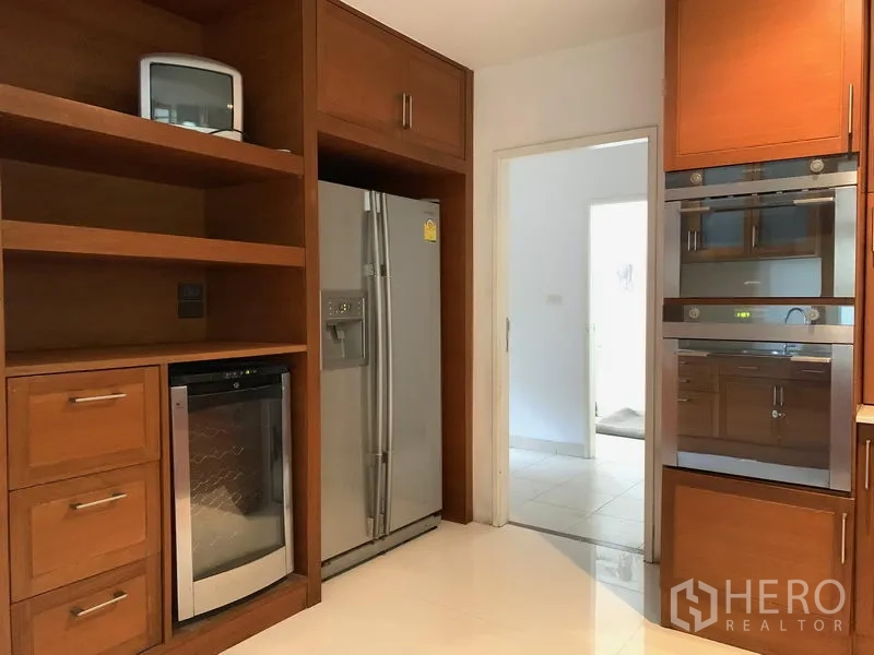 Condominium for sale in Khlong Toei, Bangkok - Kitchen storage wall with side-by-side fridge, wine cooler and twin built-in ovens.