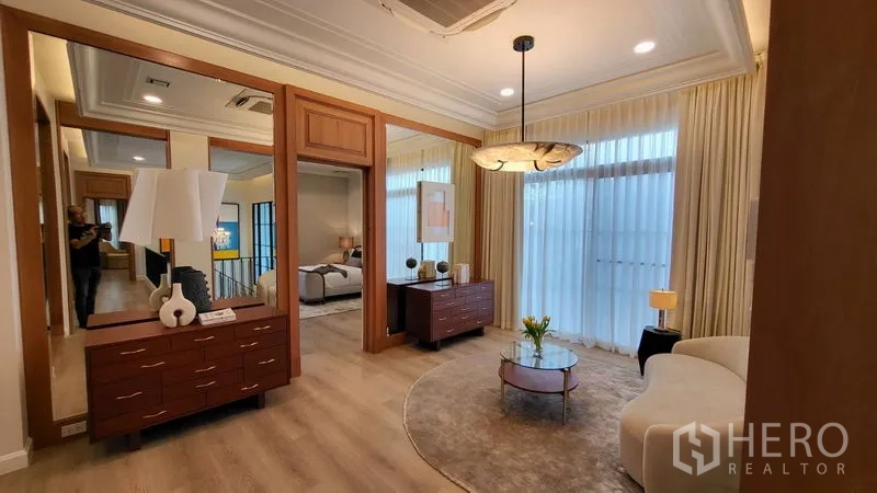Detached House for rent or sale in Saphan Sung, Bangkok - Walk-in dressing lounge with mirrors, pendant light, and curved sofa.