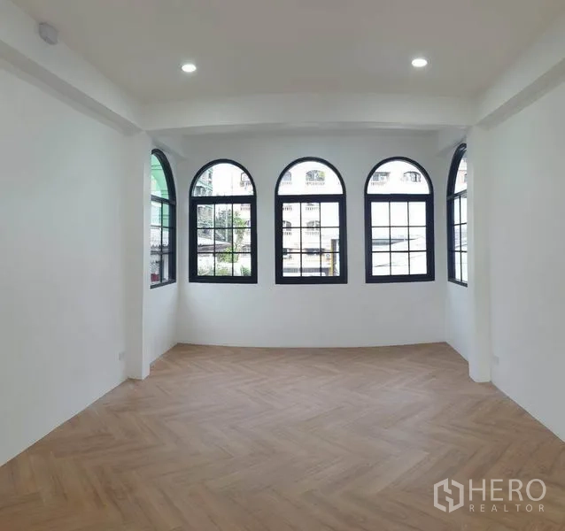 Home Office for rent or sale in Bang Na, Bangkok - Room with arched windows and herringbone wood flooring.