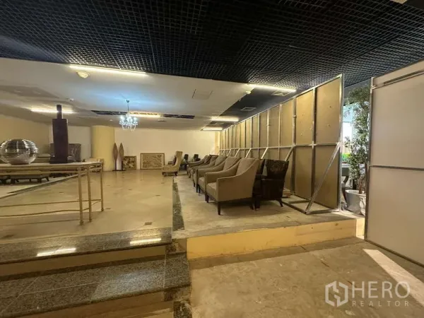 Retail Space for rent - Retail space featuring partition wall, chandelier lighting and seating on a stepped platform.