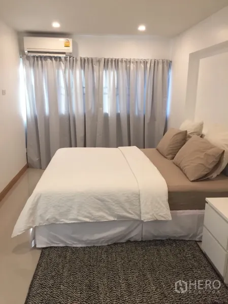 公寓 出租在Watthana, Bangkok - 温馨卧室，双人床，中性色床品，筒灯照明，空调与遮光窗帘。