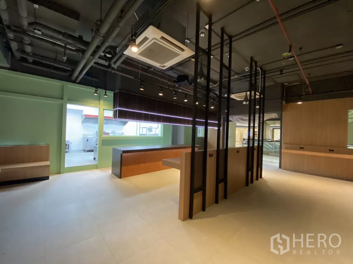 Retail Space for rent - Central island workstation with black metal partitions and doorway to the kitchen.