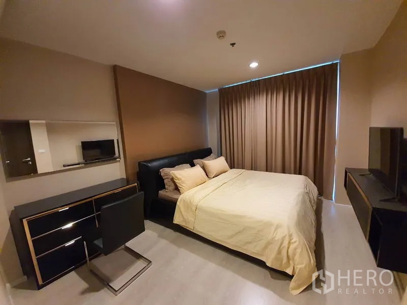 公寓 出租在Sathon, Bangkok - 主卧配大床、电视柜与遮光窗帘，配色中性温暖。