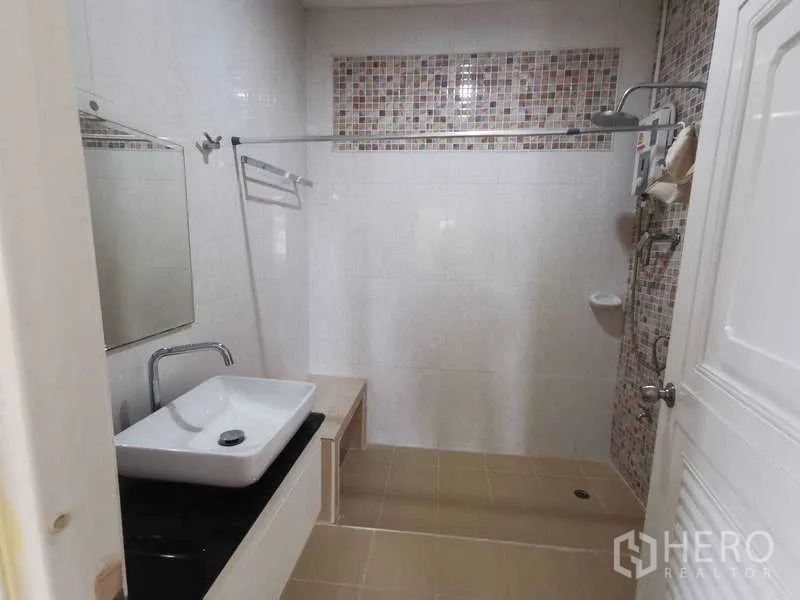 Townhouse for rent in Chatuchak, Bangkok - Bathroom with vessel sink, vanity counter and open shower area.