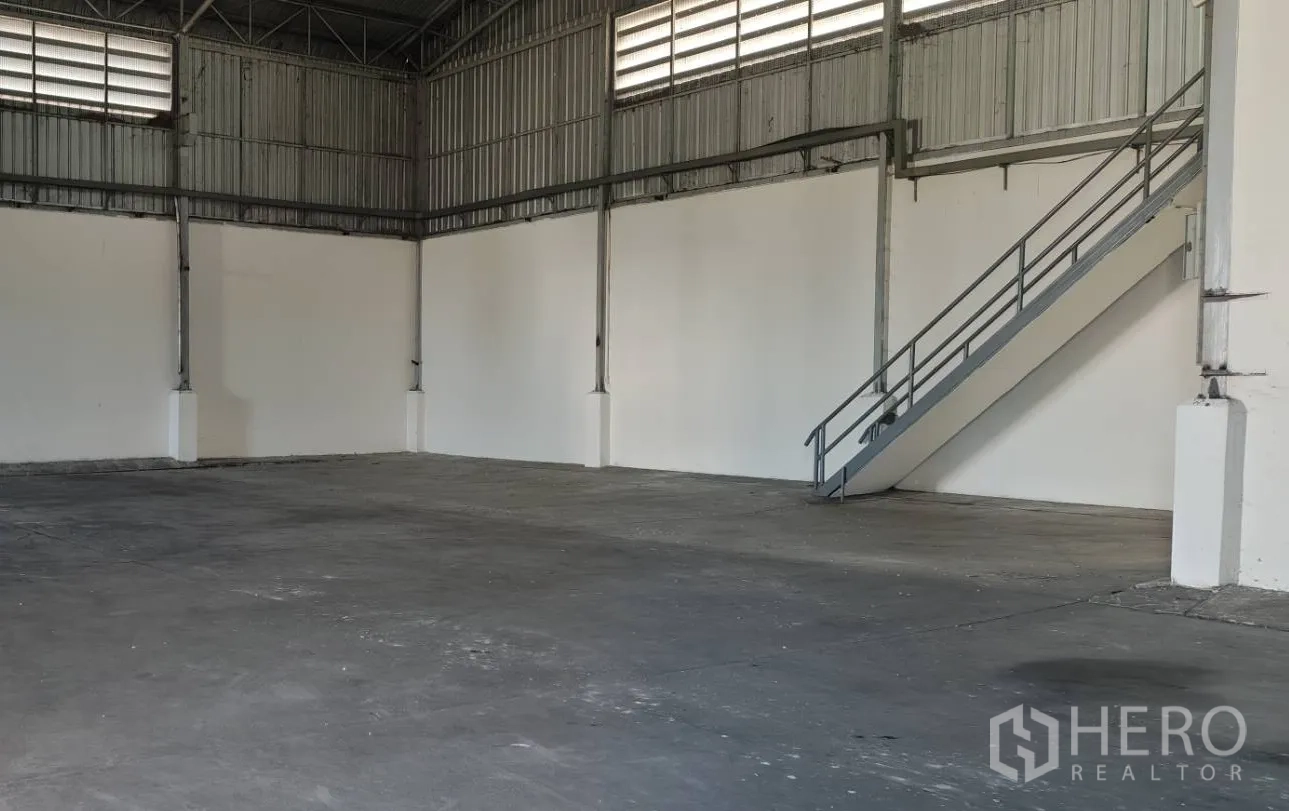 Factory for rent in Lat Lum Kaeo, Pathum Thani - Industrial hall showing steel structure, concrete floor and stairway to mezzanine office.