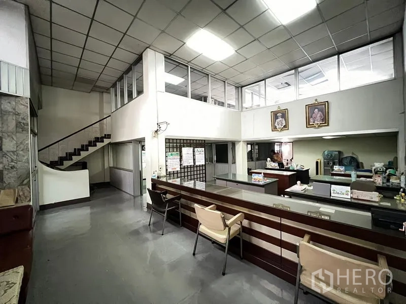 Shophouse for sale - Ground-floor reception hall with long counter and internal staircase.