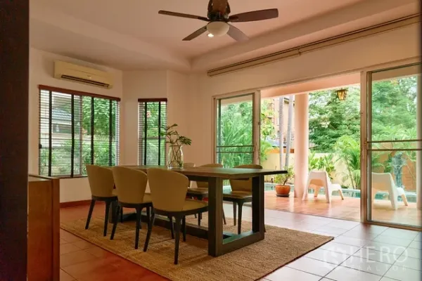 Detached House for rent in Watthana, Bangkok - Bright dining room with sliding doors opening to a poolside terrace and greenery.