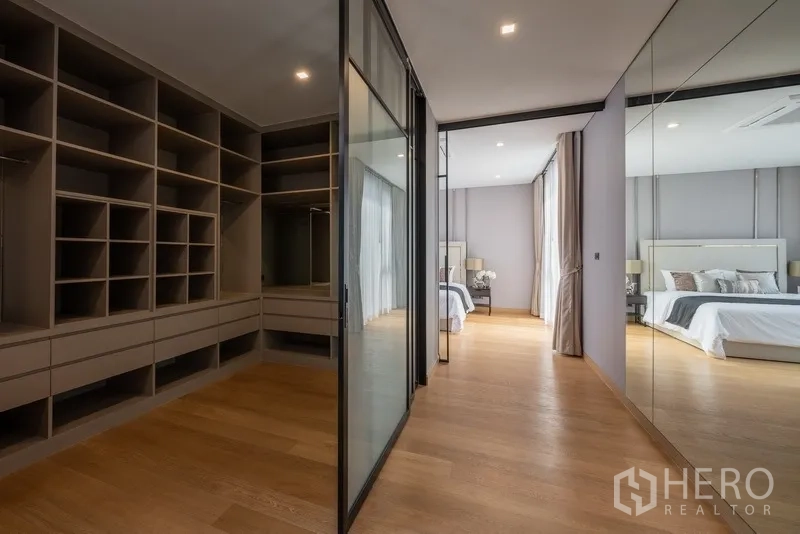 Detached House for rent or sale in Yan Nawa, Bangkok - Spacious walk-in closet with built-in shelves, glass doors and mirrored wall.